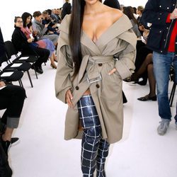 Kim Kardashian con una gabardina en el desfile de Balenciaga en la París Fashion Week