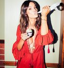 Alessandra Ambrosio posando con un jumpsuit de su propia colección con Revolve