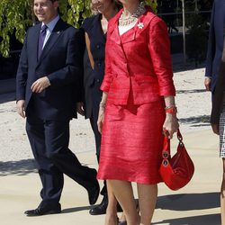 Look de la reina Sofía con vestido lady de color rojo, con textura en relieve y broche floral