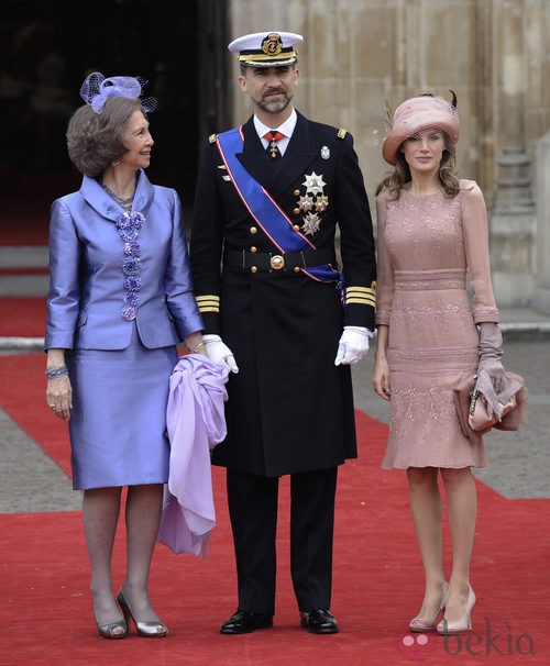 Look de la reina Sofía con vestido de gala corto de textura satinada en color malva con detalles florales en los botones