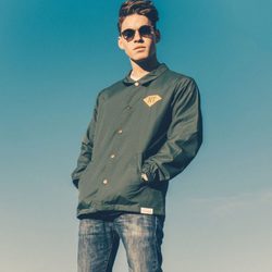 Tyler Clinton posando con una chaqueta para la agencia IMG