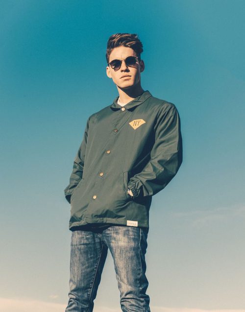Tyler Clinton posando con una chaqueta para la agencia IMG