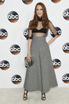 Darby Stanchfield con top negro con transparencias y pantalones culotte