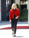 Chloë Grace Moretz con camiseta y jeans negros y cazadora roja