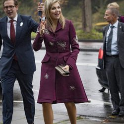 Máxima de Holanda con abrigo burdeos visitando una escuela infatil en Groningen