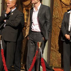 Robert Pattinson luciendo un traje gris oscuro y gafas de aviador