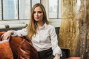 Georgina Chapman, cofundadora de Marchesa, posando con algunos diseños de fondo