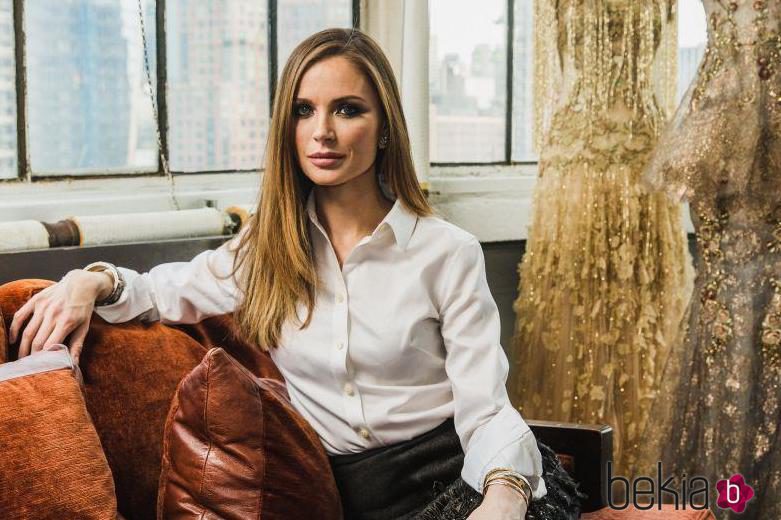 Georgina Chapman, cofundadora de Marchesa, posando con algunos diseños de fondo