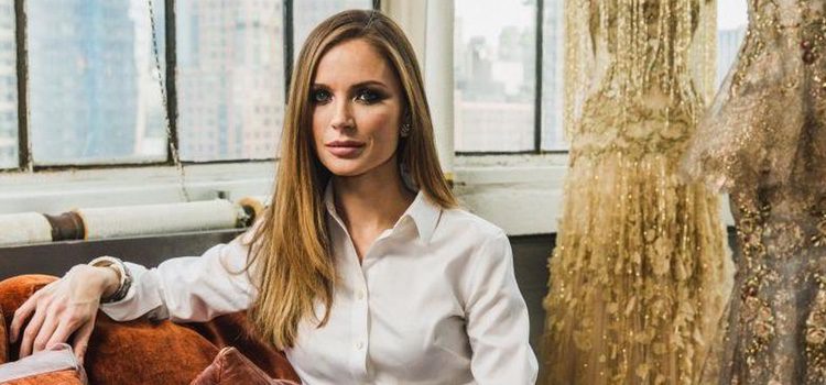 Georgina Chapman, cofundadora de Marchesa, posando con algunos diseños de fondo