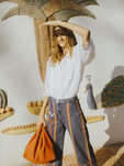 Blusa blanca ancha con bordado blanco y pantalón vaquero acabado en campana con tiras de estampado de Intropia temporada primavera/verano 2018