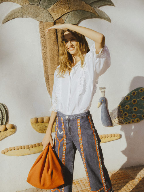 Blusa blanca ancha con bordado blanco y pantalón vaquero acabado en campana con tiras de estampado de Intropia temporada primavera/verano 2018