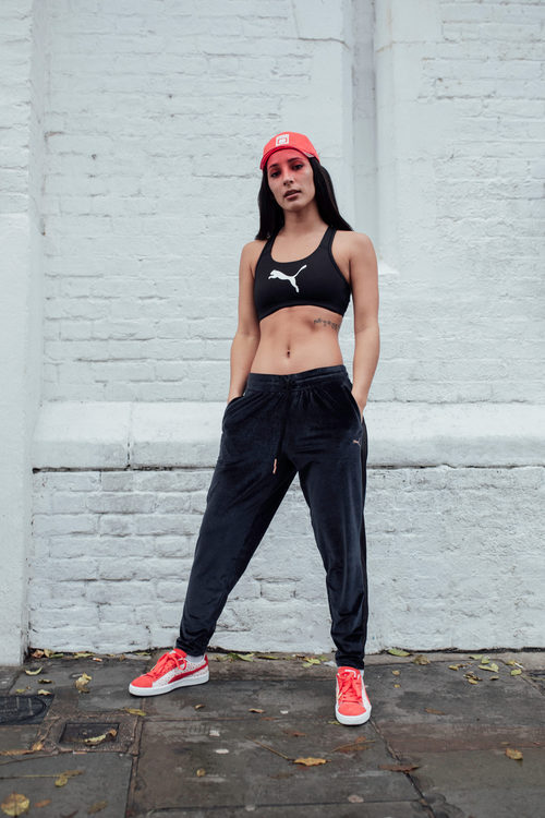 Top y pantalones deportivos negros con gorra y zapatillas de la colección Puma x Hello Kitty