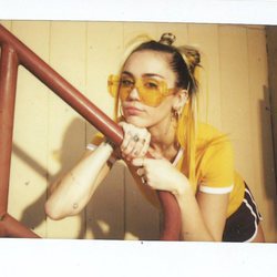Miley Cyrus posa con un pantalón corto negro y camiseta amarilla de Converse 2018
