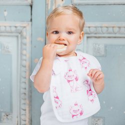 Bebé posando con un babero en color blanco con el estampado de Los Aristogatos de Disney para Aden+Anais 2018
