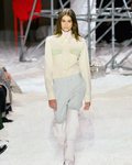 Kaia Gerber desfilando con un outfit en tonos blancos y unas botas blancas 2018