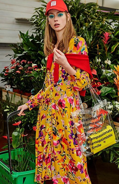 Vestido mostaza con estampado de flores con una gorra de la nueva colección de primavera 2018 de Stradivarius