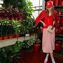 Falda rosa pastel plisada con una camiseta  y gorra roja de la nueva colección de primavera 2018 de Stradivarius