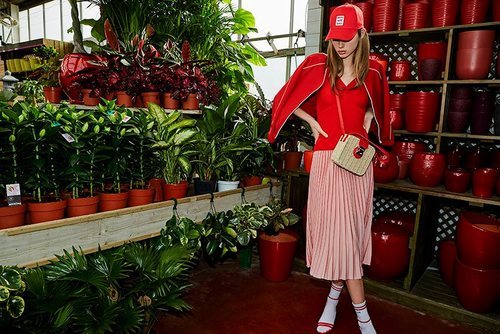 Falda rosa pastel plisada con una camiseta y gorra roja de la nueva colección de primavera 2018 de Stradivarius