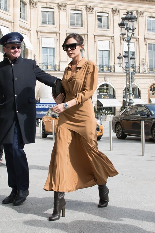 Victoria Beckham con una falda midi y camisa camel en Paris 2018