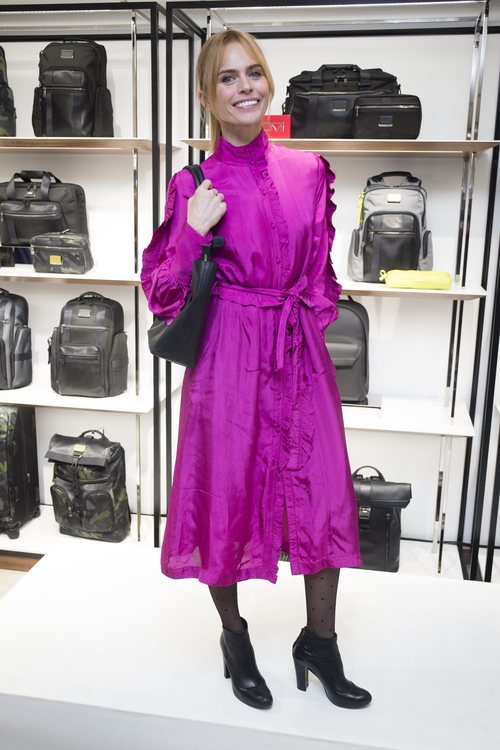 Veronica Blume con un vestido midi rosa chillón en la inauguración de Tumi