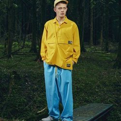 Modelo con un pantalón azul y camisa amarilla de la nueva línea de Outdoor de la nueva colección SS19 de Woolrich