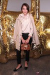 Alexa Chung con pitillo negro y abrigo beige