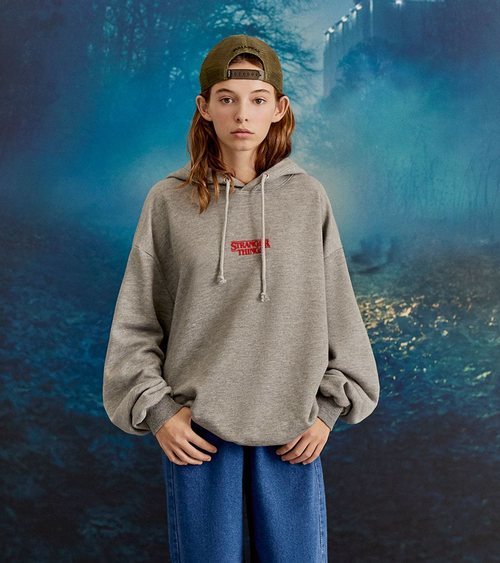 Modelo con una sudadera gris de la colección cápsula de Stranger Things 2018