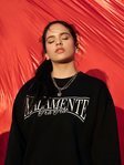 Rosalía con una sudadera con el mensaje 'malamente' de su colección para Pull and Bear