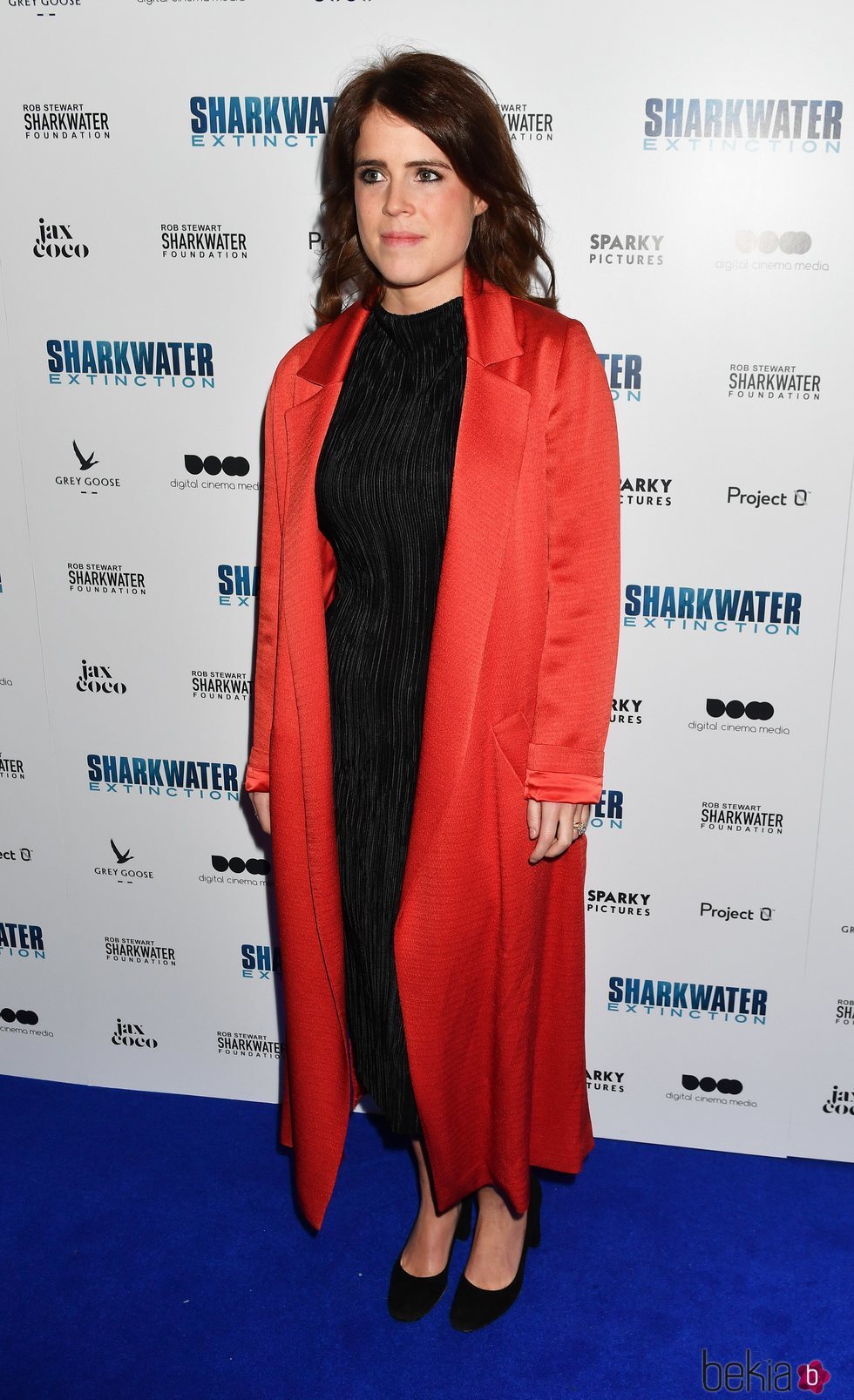 Eugenia de York con un vestido negro y abrigo coral