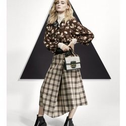 Sophie Turner con una blusa estampada y una falda midi posando para el lookbook Pre-Fall 2019 de Louis Vuitton