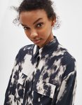 Modelo luciendo una camisa estampada en tonos oscuros de la colección de primavera 2019 de Bershka
