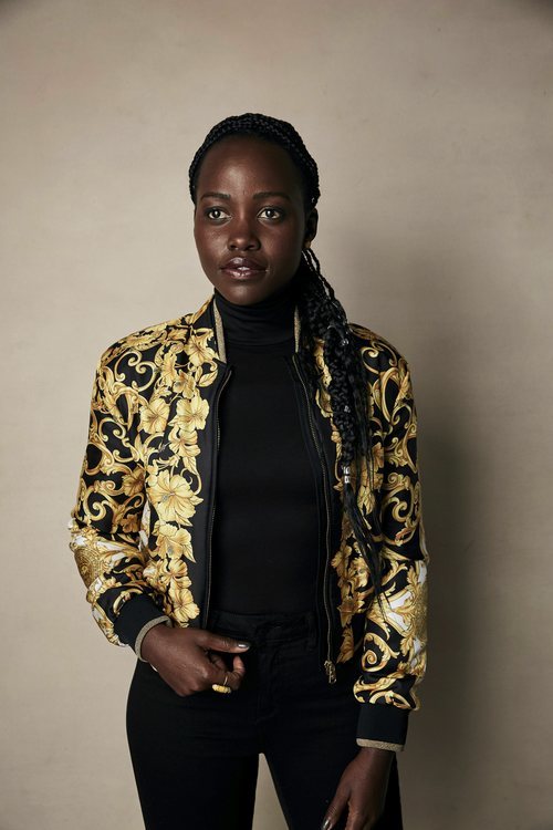 Lupita Nyongo vestida de negro y chaqueta de flores