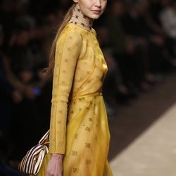 Gigi Hadid con un vestido amarillo superpuesto a un body en el desfile otoño/invierno 2019/2020 de Fendi