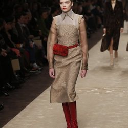 Modelo con un vestido en tonos marrones y complementos rojos en el desfile otoño/invierno 2019/2020 de Fendi
