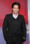 Brian Atwood con traje chaqueta negro y jersey del mismo tono