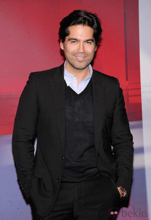 Brian Atwood con traje chaqueta negro y jersey del mismo tono