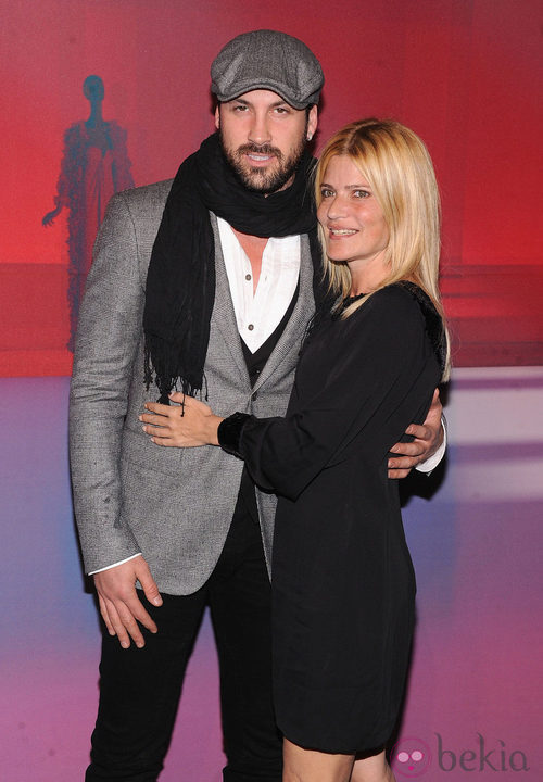 Maksim Chmerkovskiy con chaqueta gris de cuadros y Lizzie Grubman con vestido negro 