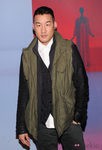 Richard Chai con look informal y parca verde en chaleco