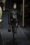 Bella Hadid desfilando con un look total black de Moschino otoño/invierno 2019/2020 en la Milán Fashion Week