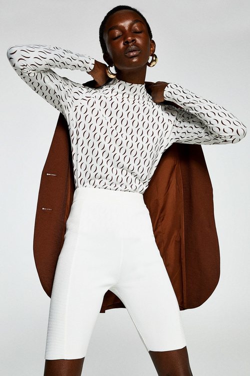 Modelo con un conjunto marrón y blanco de la colección primavera/verano 2019 de Sfera