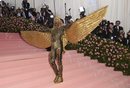 Billy Porter con un mono dorado con grandes alas en la alfombra roja de la Gala MET 2019