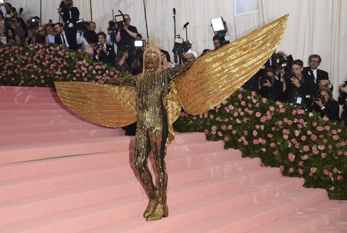 Billy Porter con un mono dorado con grandes alas en la alfombra roja de la Gala MET 2019