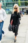 Rita Ora con look 'total black' de vestido satinado en el aeropuerto de Heathrow