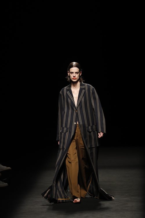 Abrigo fluido largo de rayas y pantalón de pinzas estilo cargo en el desfile primavera/verano 2020 de Juanjo Oliva en la MBFWMadrid julio 2019