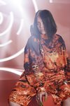 Billie Eilish con conjunto de chándal corto en naranja y negro de la colección Billie Eilish x Bershka