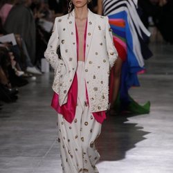 Traje de sastrería oversize en color blanco con incrustaciones de perlas y detalles dorados durante el defile Alta Costura primavera/verano 2020 de Schiapa