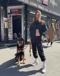 Emily Ratajkowski con un look total black sport paseando a su perro por Nueva York
