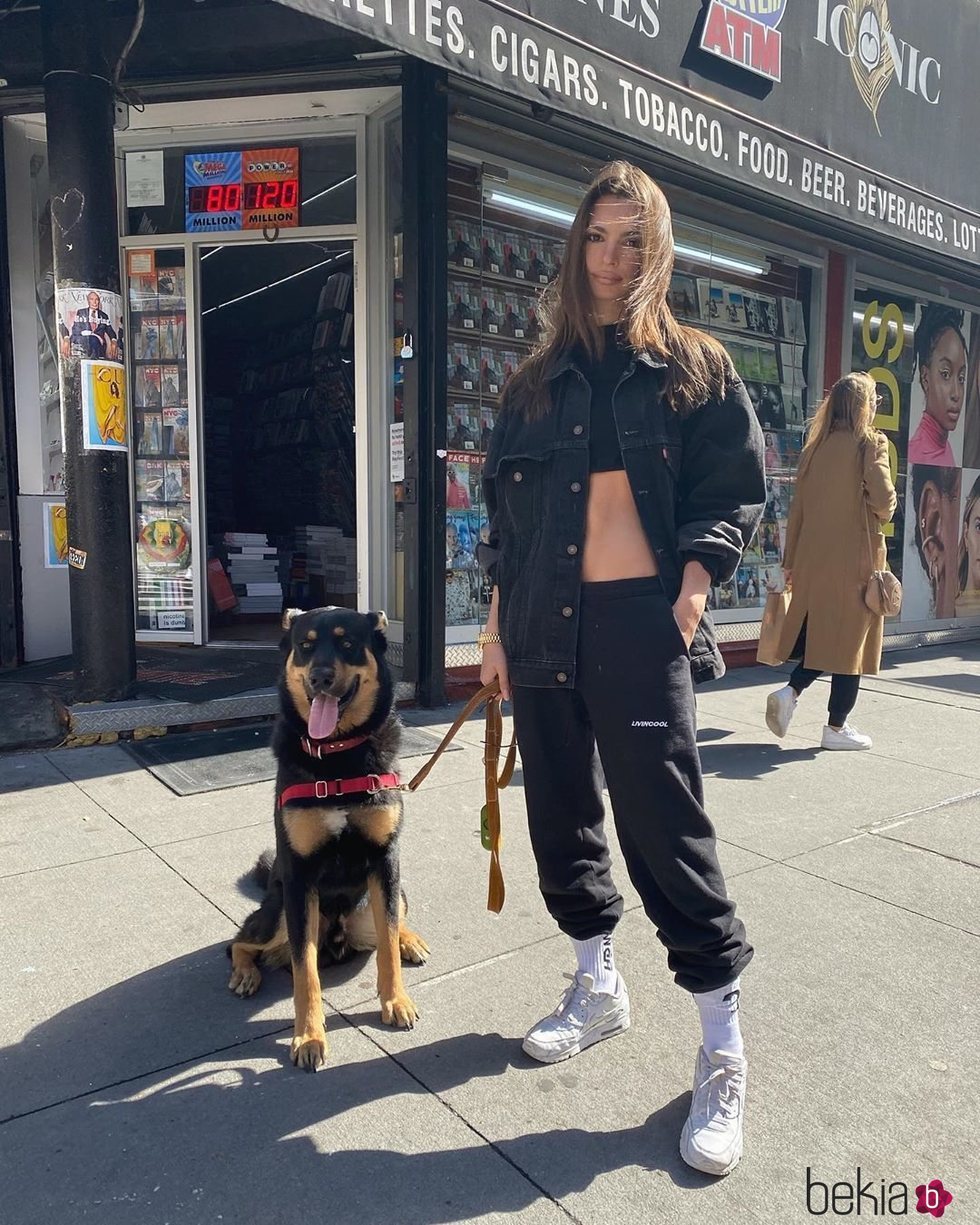 Emily Ratajkowski con un look total black sport paseando a su perro por Nueva York