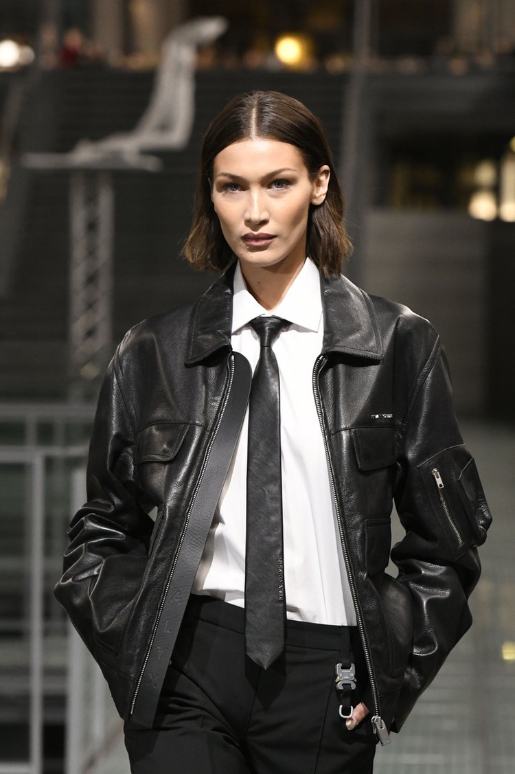 Bella Hadid durante un desfile en París luciendo un look con corbata