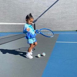 Stormi Webster con un look tie dye en azul y blanco jugando al tenis